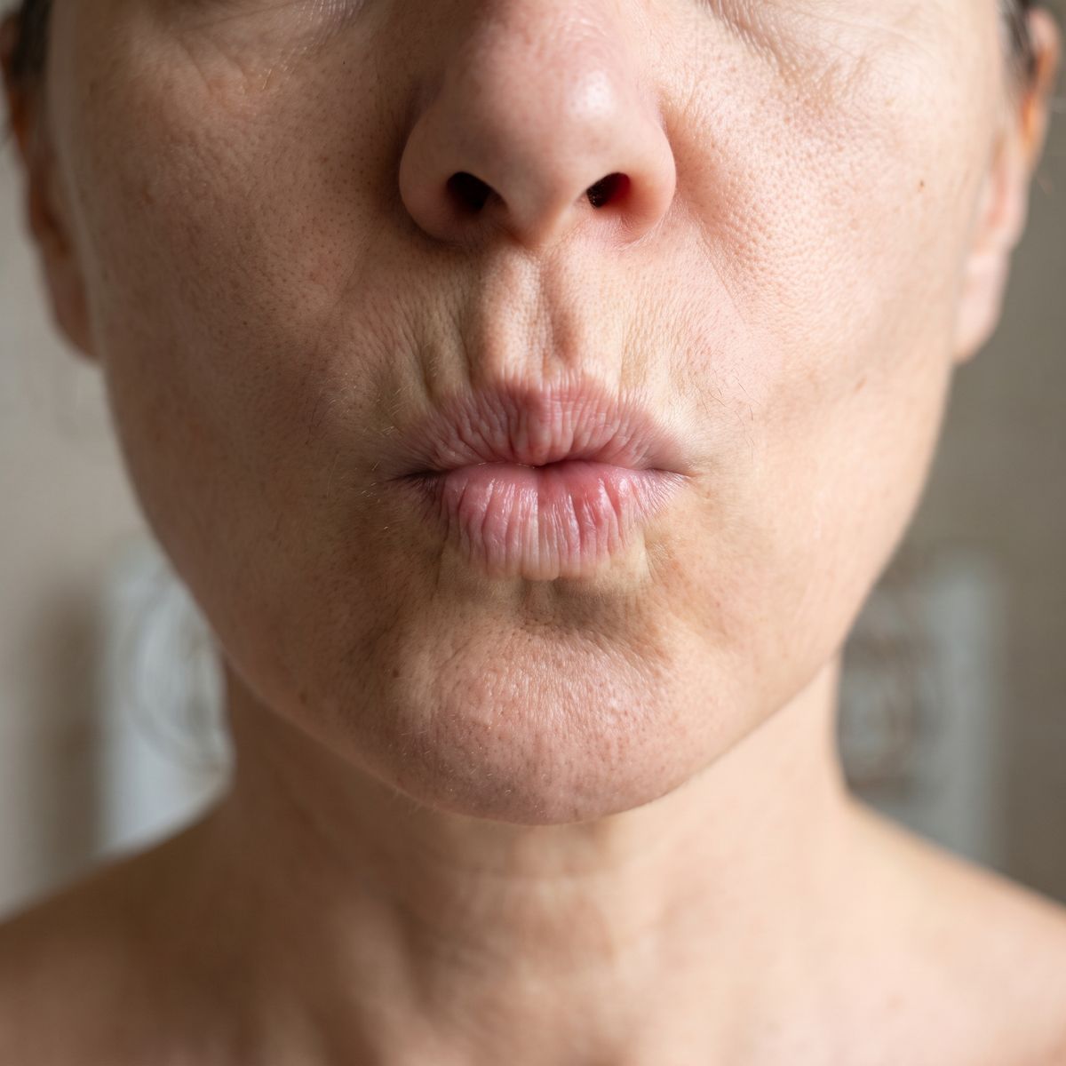 Femme mature qui fait la moue : les rides verticales au-dessus de la lèvre apparaissent